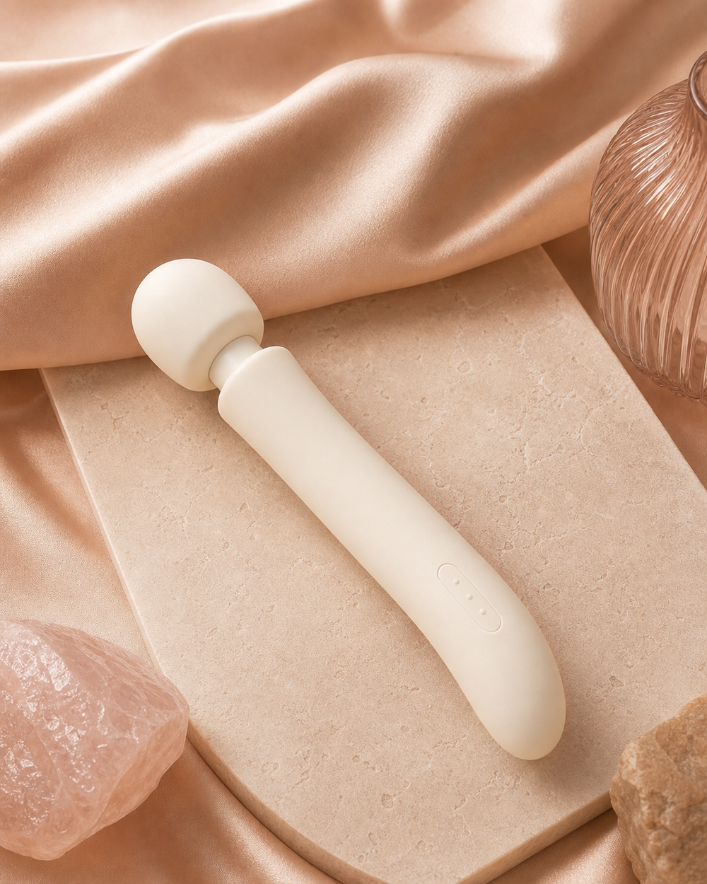 The Body Wand — a contoured silicone massage tool in warm marble light